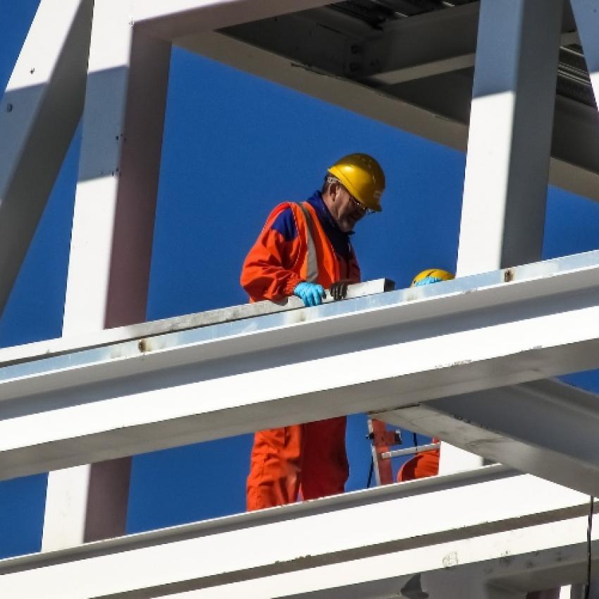 Homme dans le bâtiment qui travaille avec une combinaison orange.