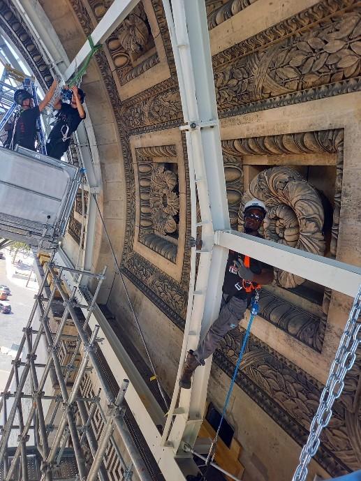 Des ouvriers travaillent sur l'Arc de Triomphe.